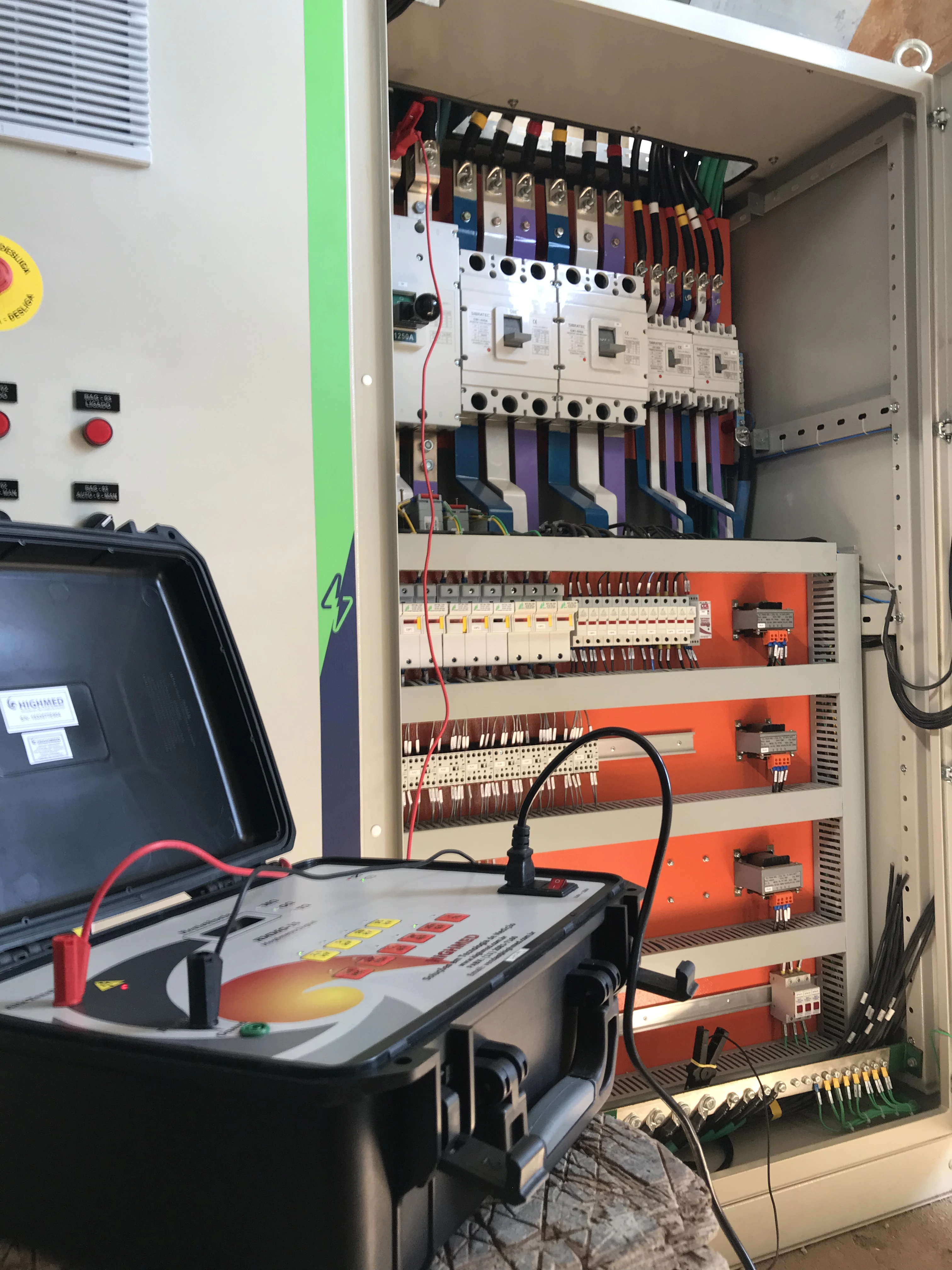 Técnico realizando ensaio de resistência de isolamento em painel com megômetro