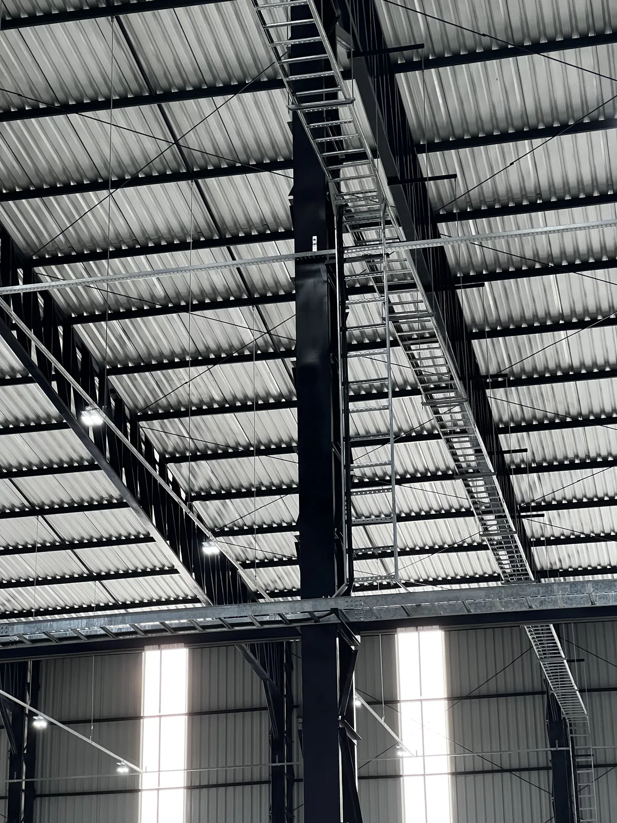 Escadas e eletrocalhas de cabos instaladas na cobertura de galpão industrial