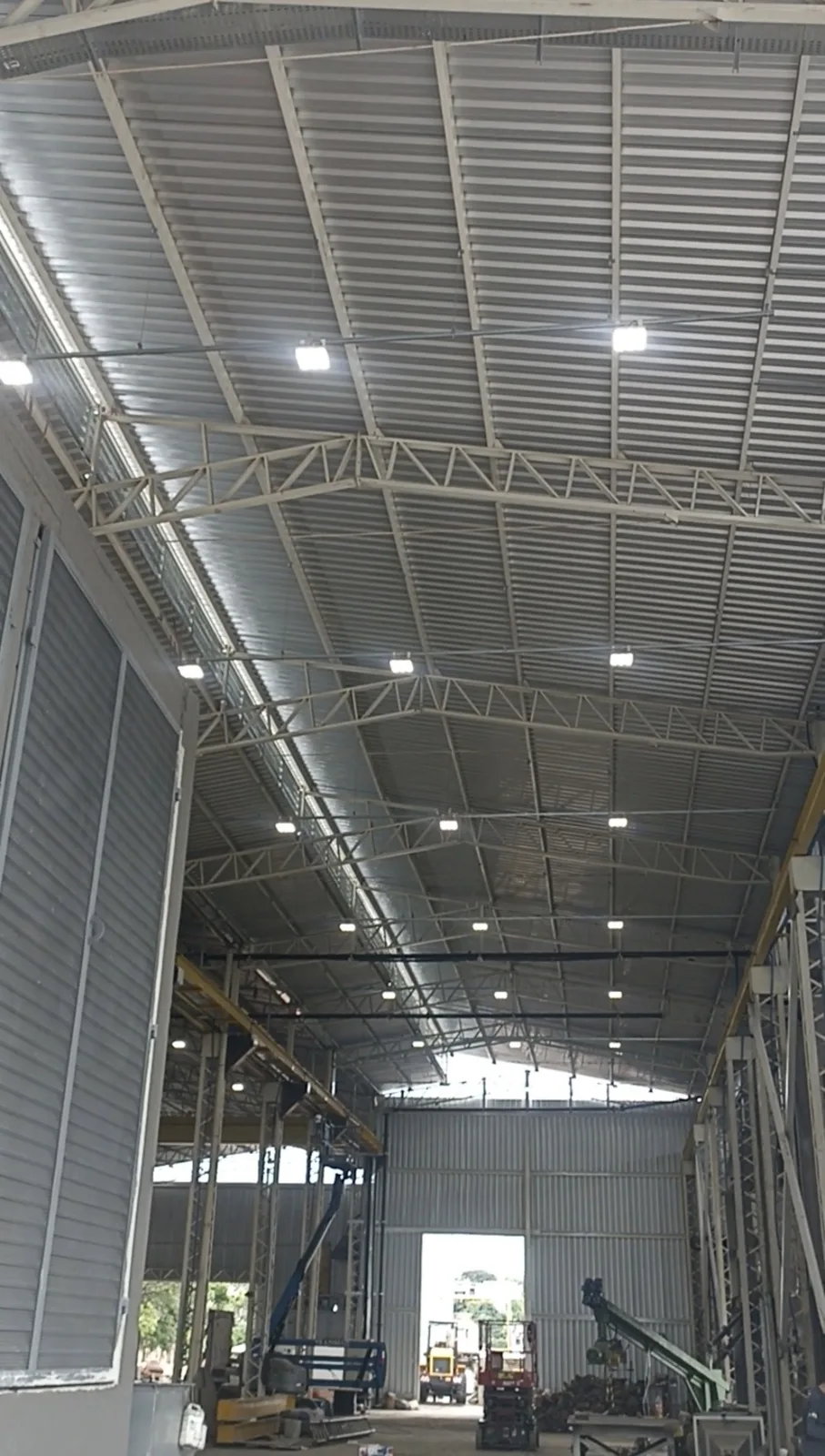 Estrutura metálica de galpão industrial com luminárias LED instaladas