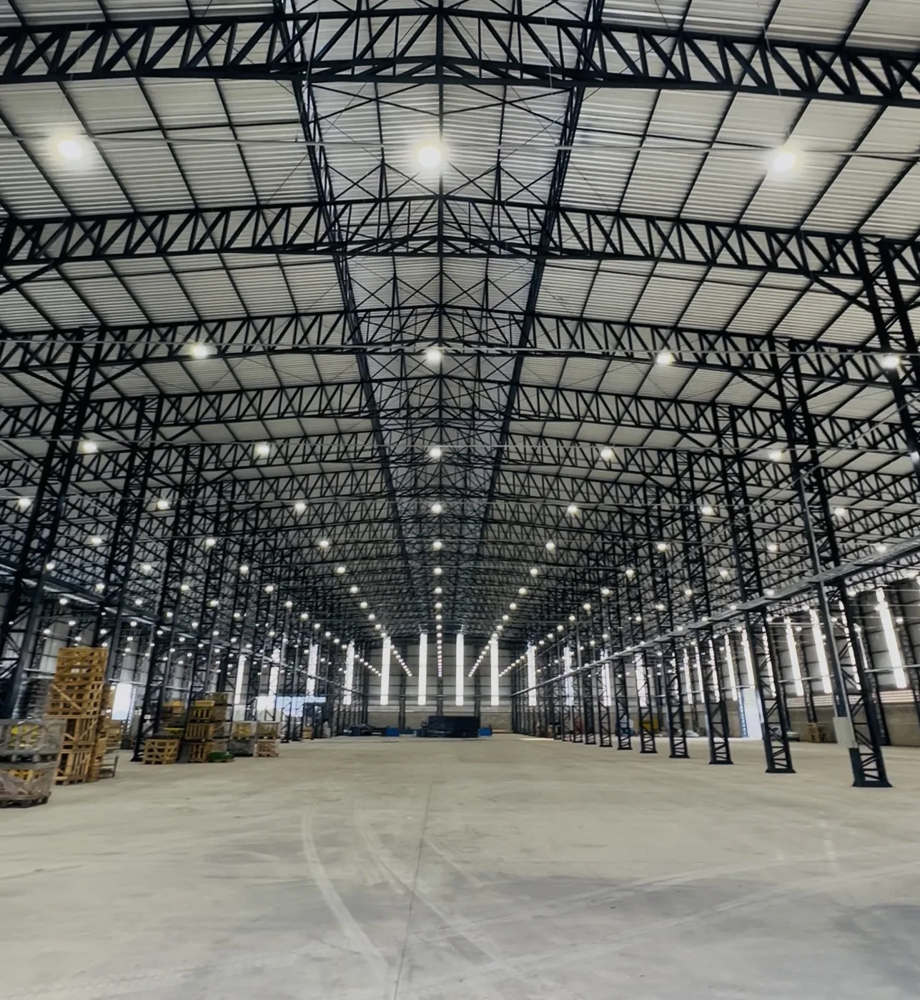 Galpão industrial iluminado por luminárias LED distribuídas em toda a cobertura