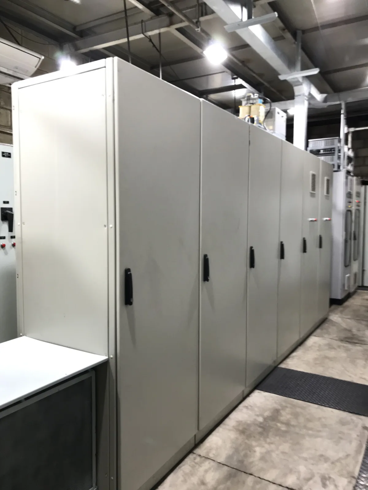 Fileira de painéis elétricos industriais montados lado a lado