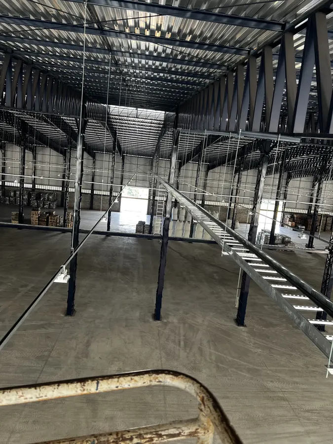 Galpão industrial em obra com eletrocalhas e infraestrutura elétrica sendo instalada