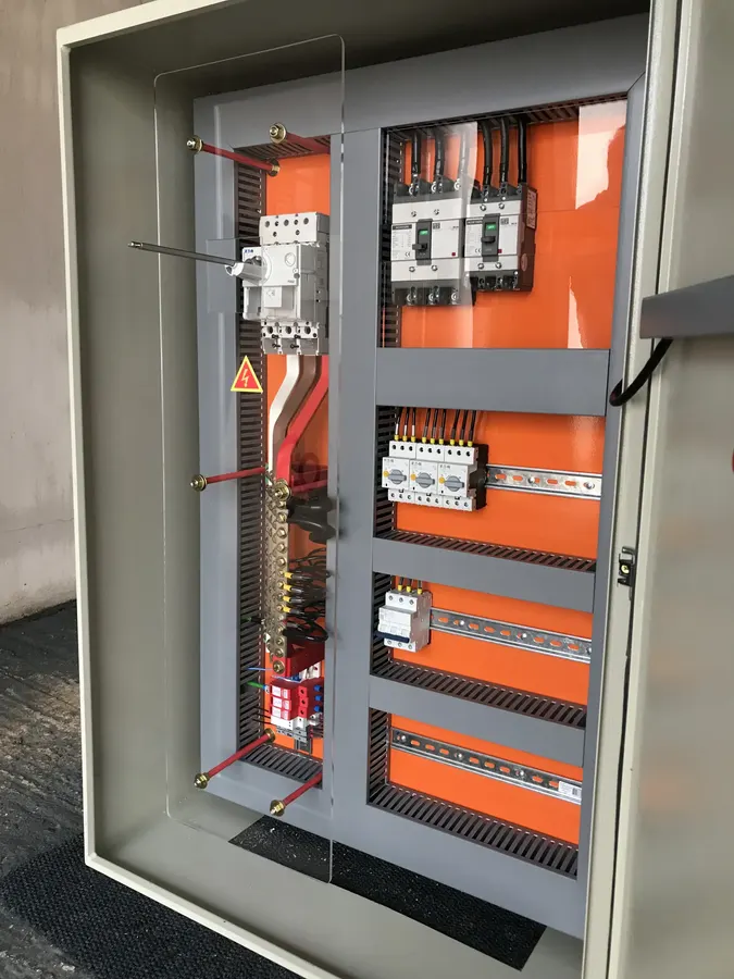 Detalhe de painel elétrico com disjuntores e barramentos de cobre